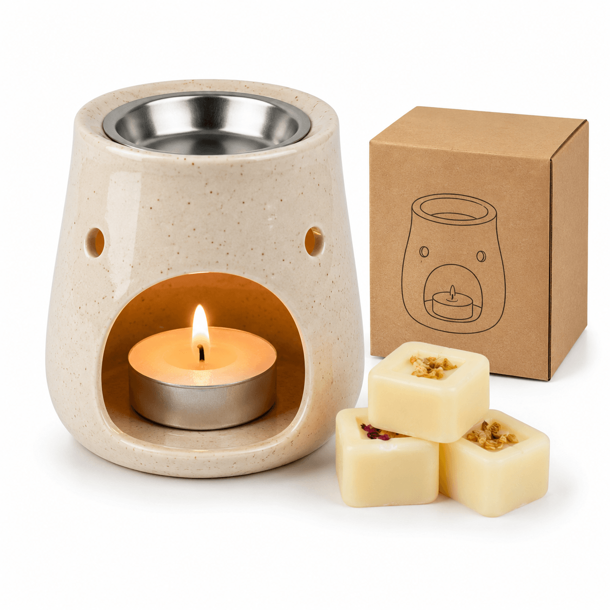 Ceramic wax warmer with a lit candle, three wax melts, and a cardboard box on a white background