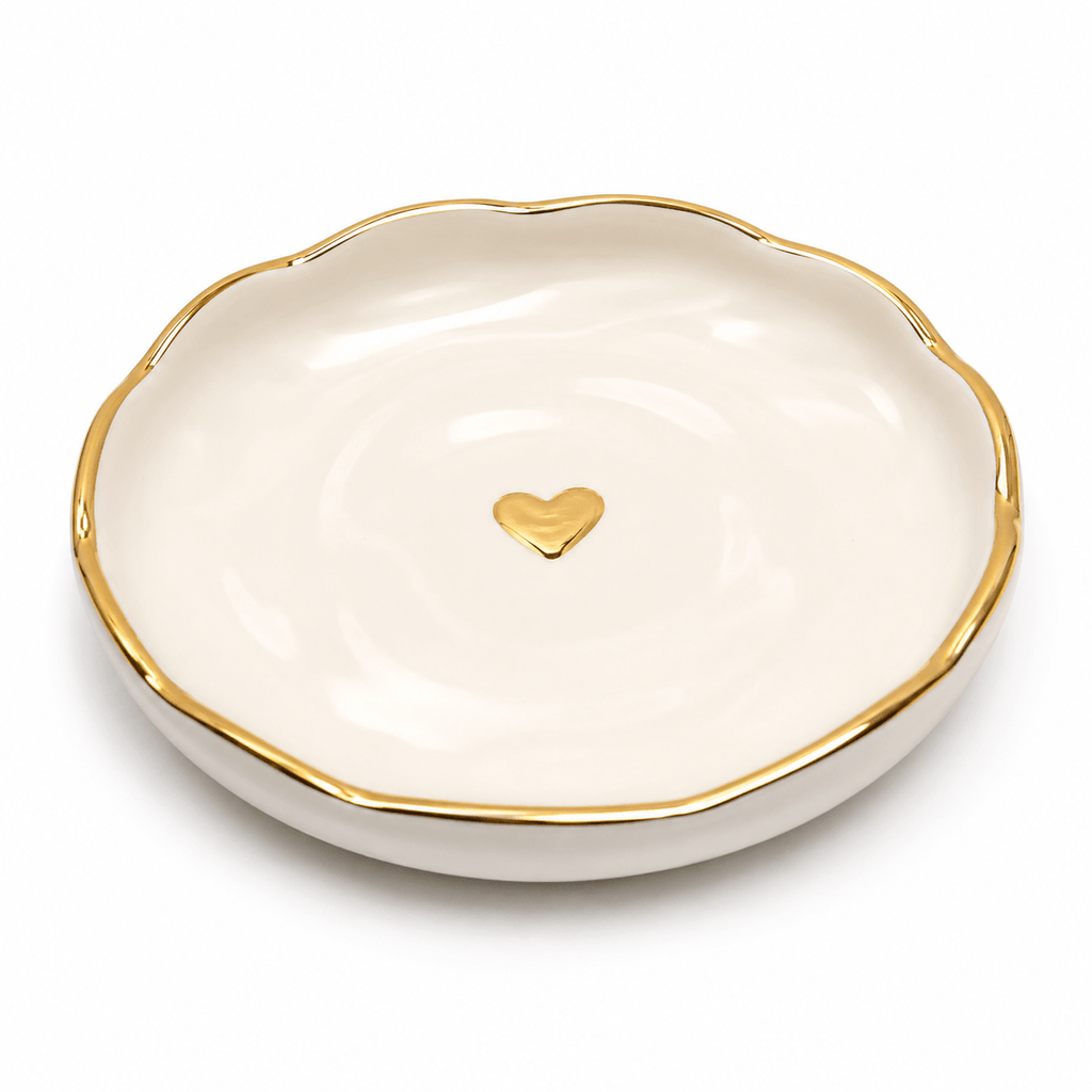 White dish with gold rim and heart-shaped gold emblem on a white background