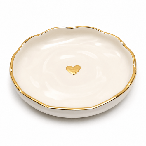 White dish with gold rim and heart-shaped gold emblem on a white background